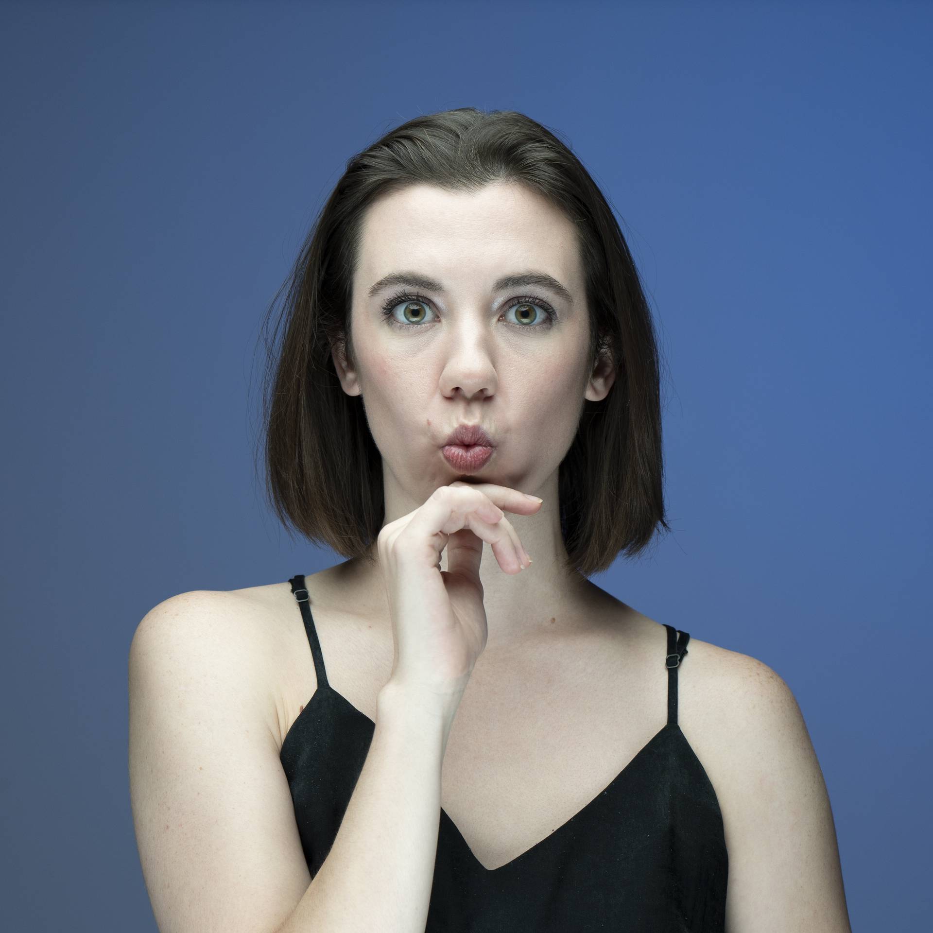 Woman model making a fun O face with blue background